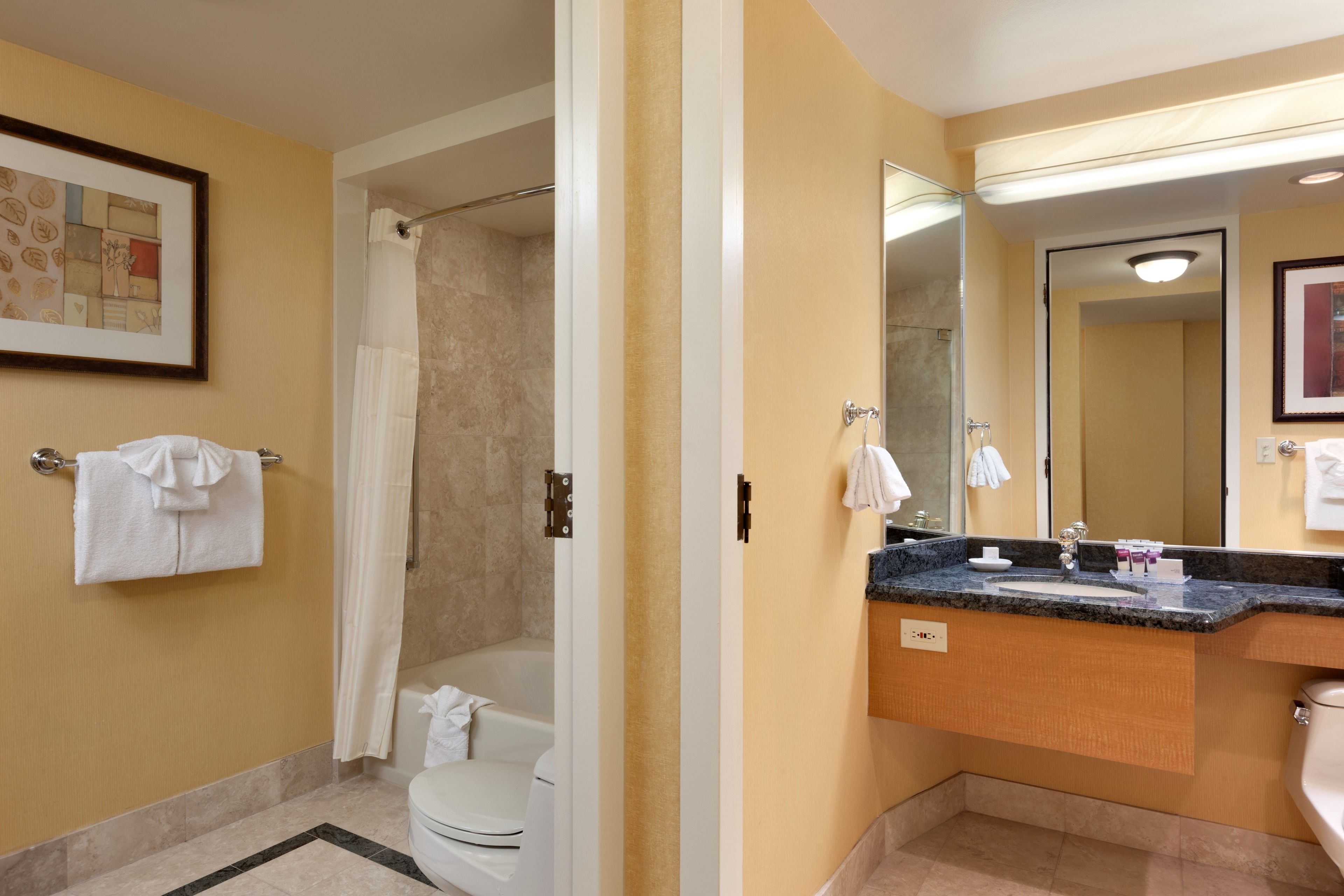A modern bathroom with a shower, toilet, and vanity.