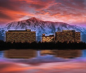 Two large hotels, Harrah's and Caesars Republic, with illuminated windows and a mountain backdrop. - Harrah's Lake Tahoe Hotel & Casino – A Caesars Rewards Destination (Stateline)