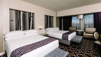 Habitación de hotel con dos camas, un sofá, una silla y vistas a la ciudad.