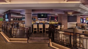 Un amplio bar con diversas opciones de asientos, una pantalla de televisión y una variedad de equipos de bar.