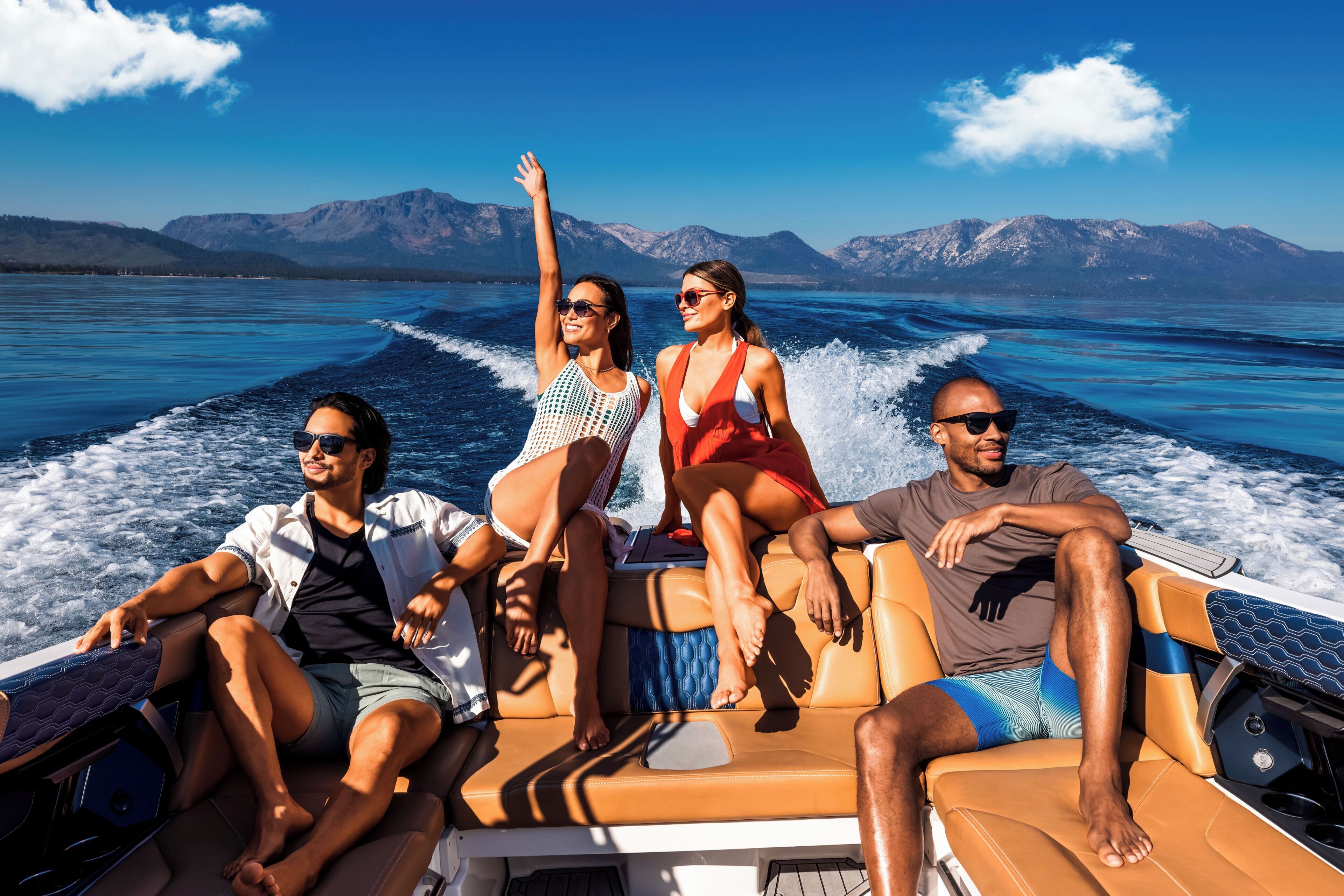 Un grupo de personas en un barco frente a un paisaje montañoso.
