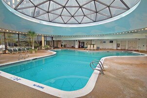 Una piscina techada, sillones reclinables de piscina