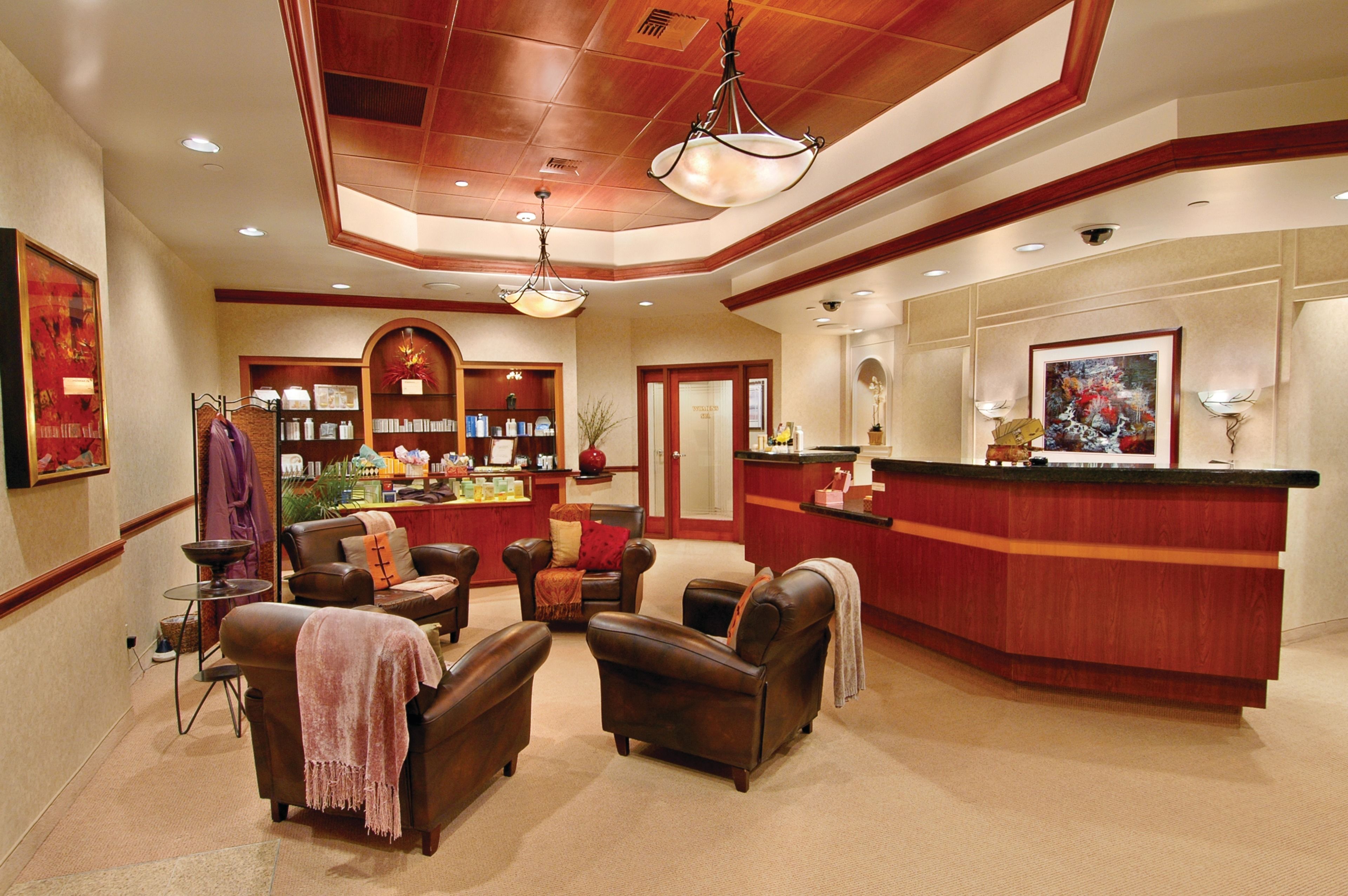 A lobby with leather sofas, a reception desk, and a display of items on shelves.