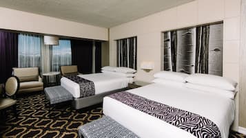 Ein Hotelzimmer mit zwei Betten, einem Sofa, einem Sessel und einem gemusterten Teppich.
