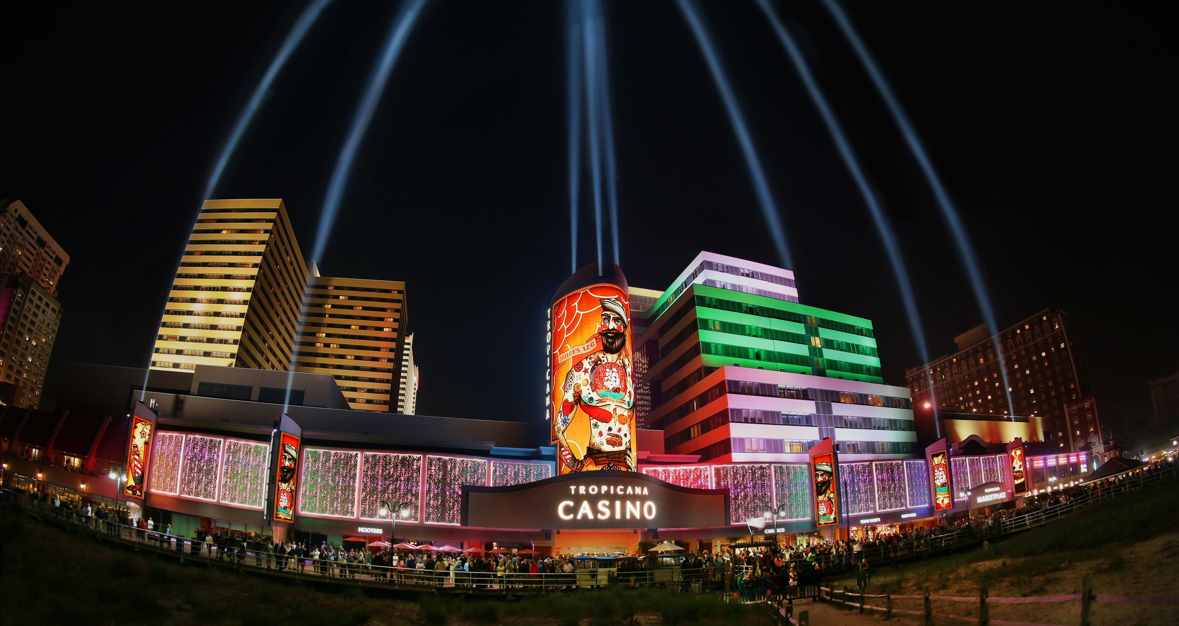 A casino with a large illuminated sign and multiple levels of buildings.