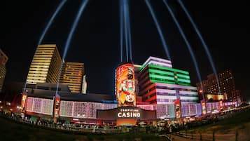 A casino with a large illuminated sign and multiple levels of buildings.