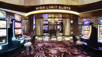 Experience the excitement of the casino area, where high-limit slots offer thrilling games and plush chairs provide comfortable seating.