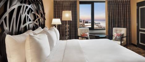 Ein Hotelzimmer mit einem großen Bett, Blick auf die Stadt und einer Wanddekoration.