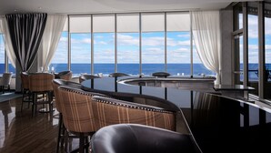 Ein moderner Essbereich mit weitem Panoramablick auf das Meer, ausgestattet mit einem runden Tisch und bequemen Sitzgelegenheiten.