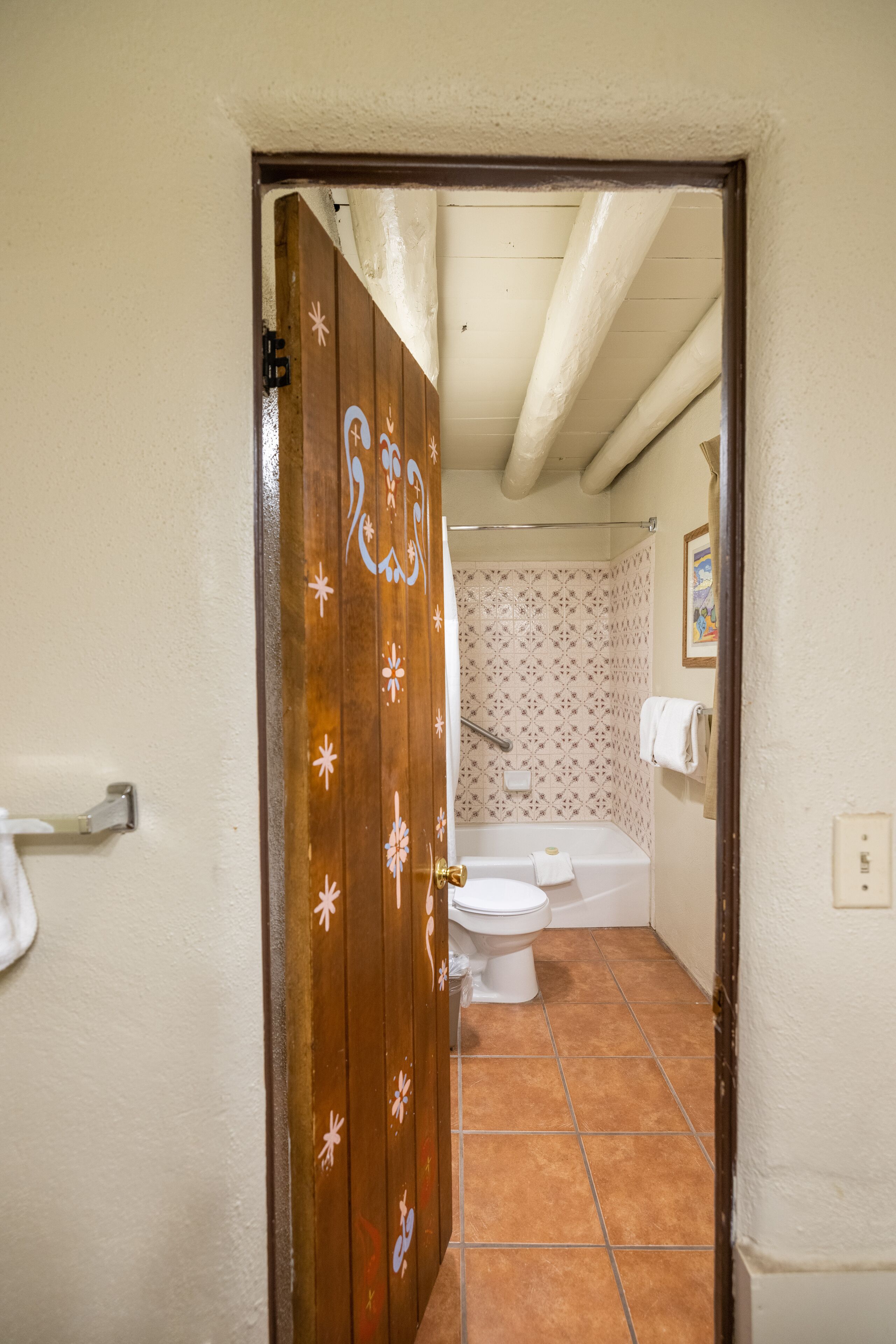 A bathroom with a toilet, bathtub, and shower.