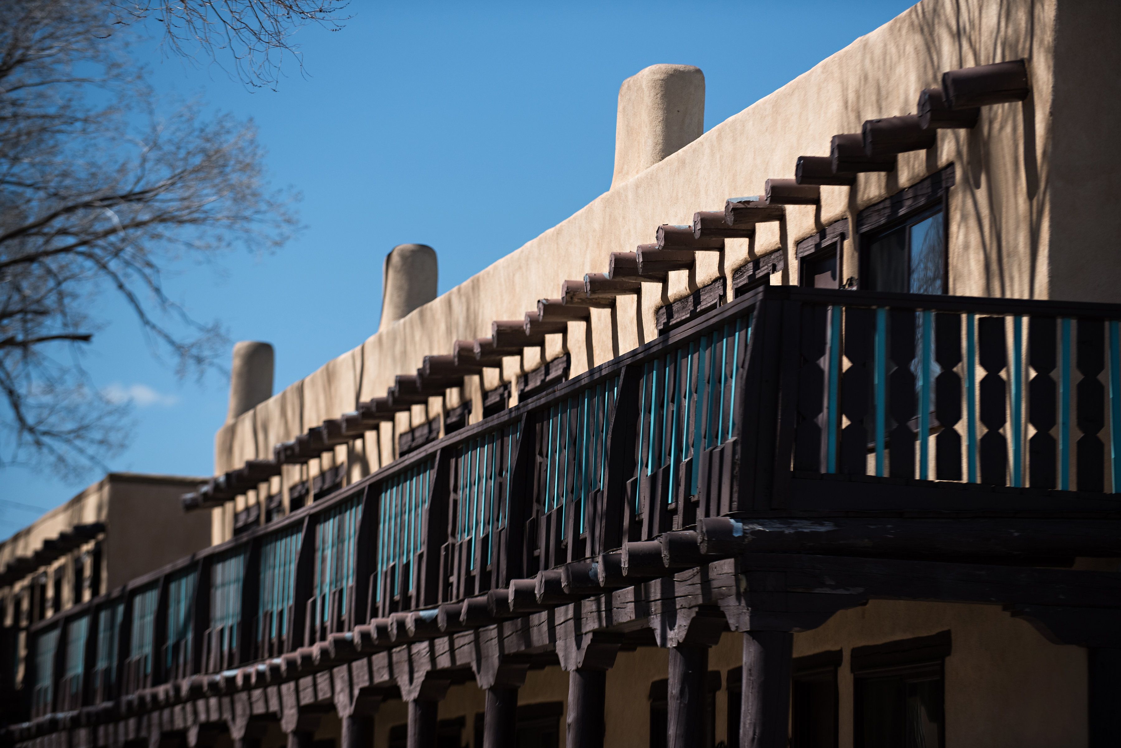 Ein Gebäude mit Balkon, Holellentrailierung und Fenster mit blauem Rahmen.