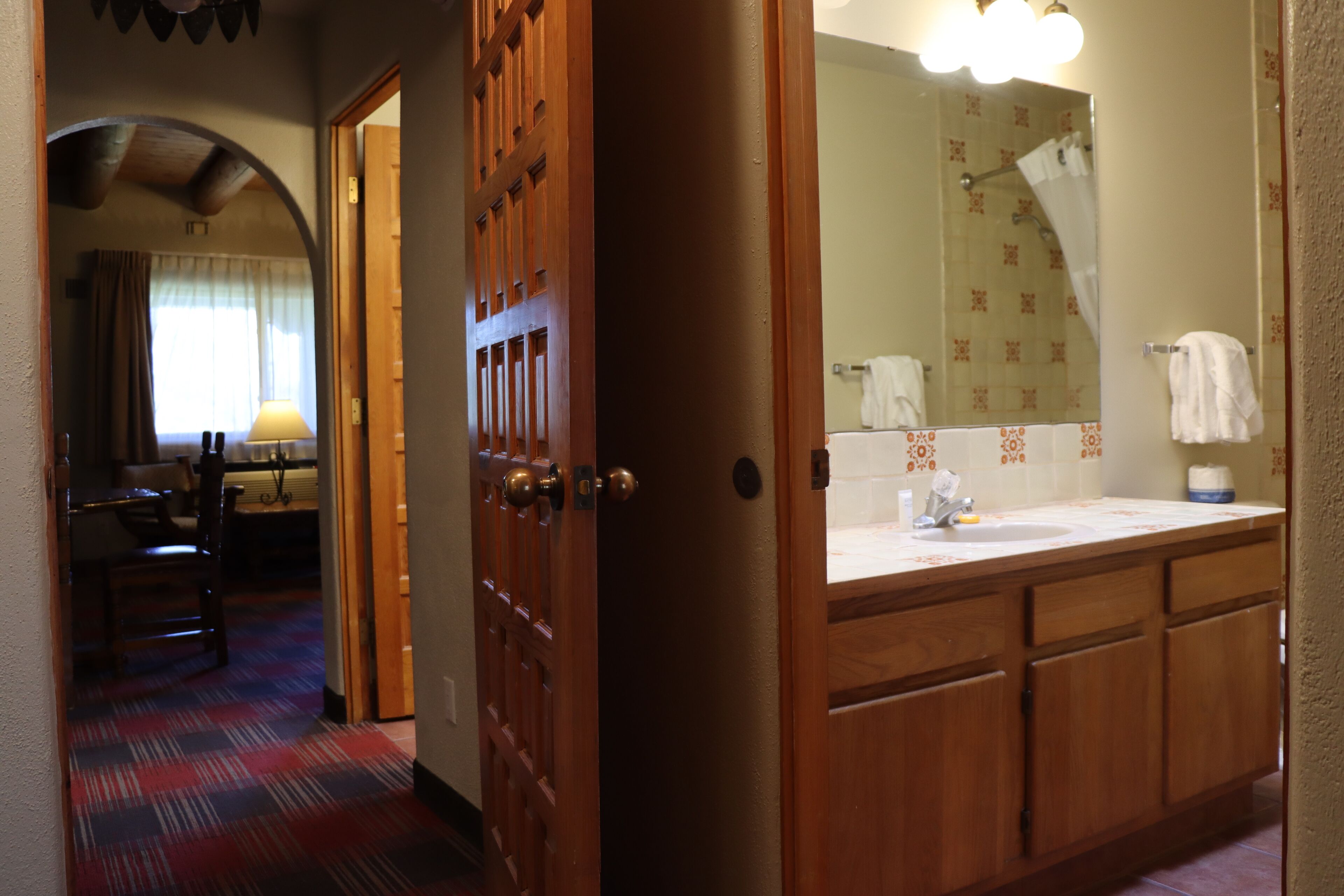 Ein Hotelbad mit Holzausstattung, einem Waschbecken und einem Spiegel.