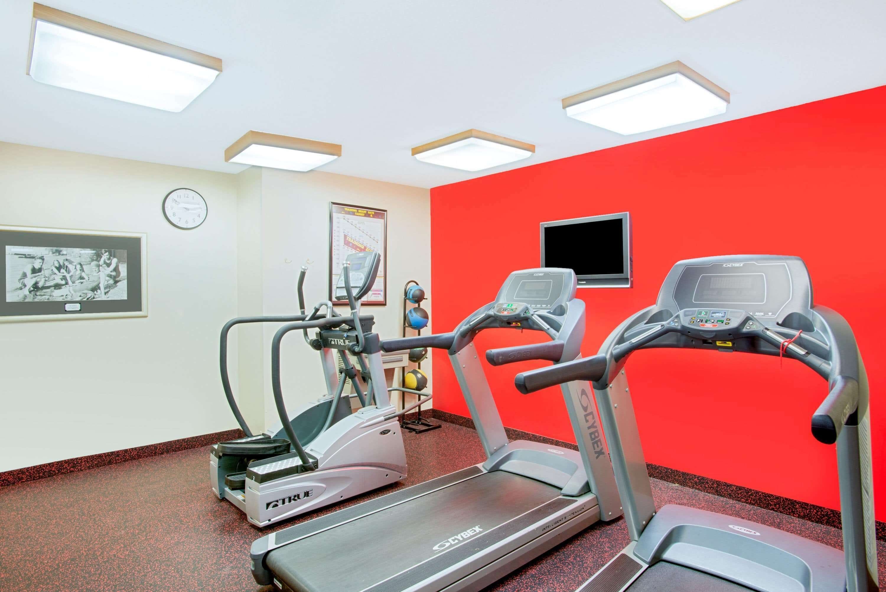 A gym with treadmills, an elliptical, and a stationary bike.