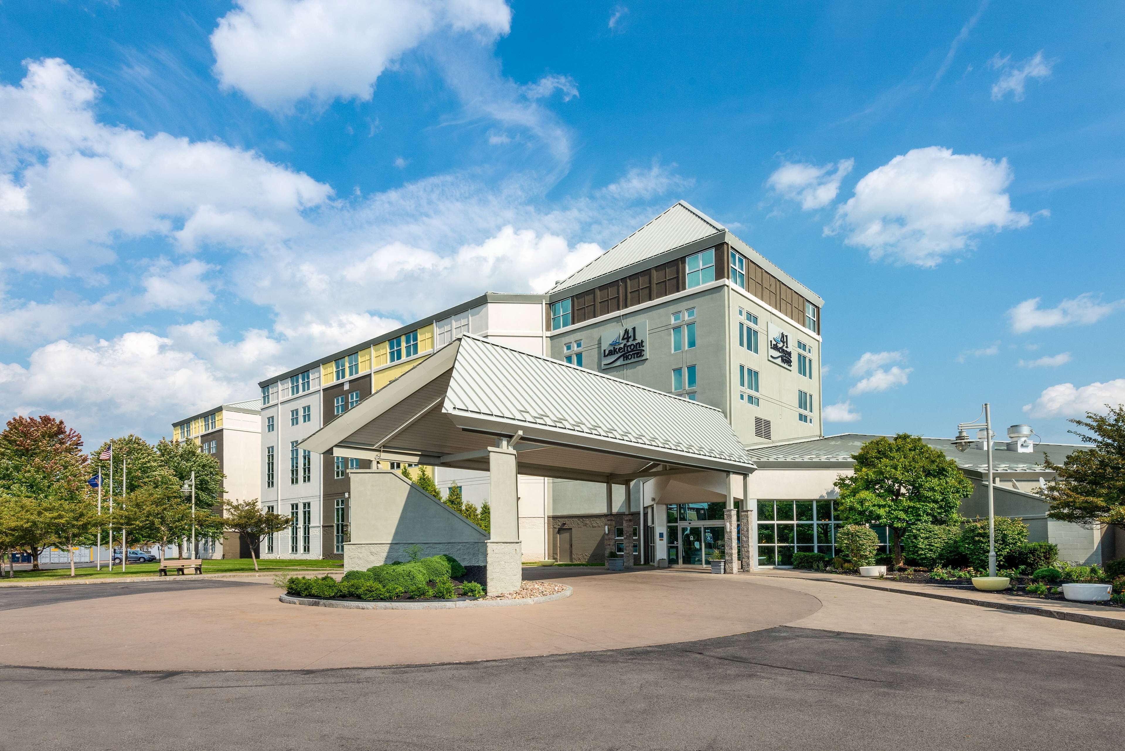 A modern hotel with a covered entrance, multiple floors, and a prominent sign.