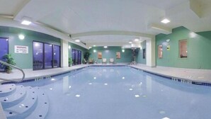 An indoor swimming pool with a clear view of the pool area, including the pool's edge, steps leading into the pool, and a warning sign on the wall. - Holiday Inn Express Wilmington by IHG (Wilmington)