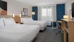 A hotel room with two beds, a desk, a chair, and a TV. - Spark by Hilton Lancaster (Lancaster)