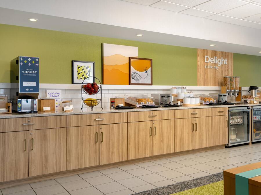 A modern kitchen with wooden cabinets, a coffee machine, and a refrigerator.