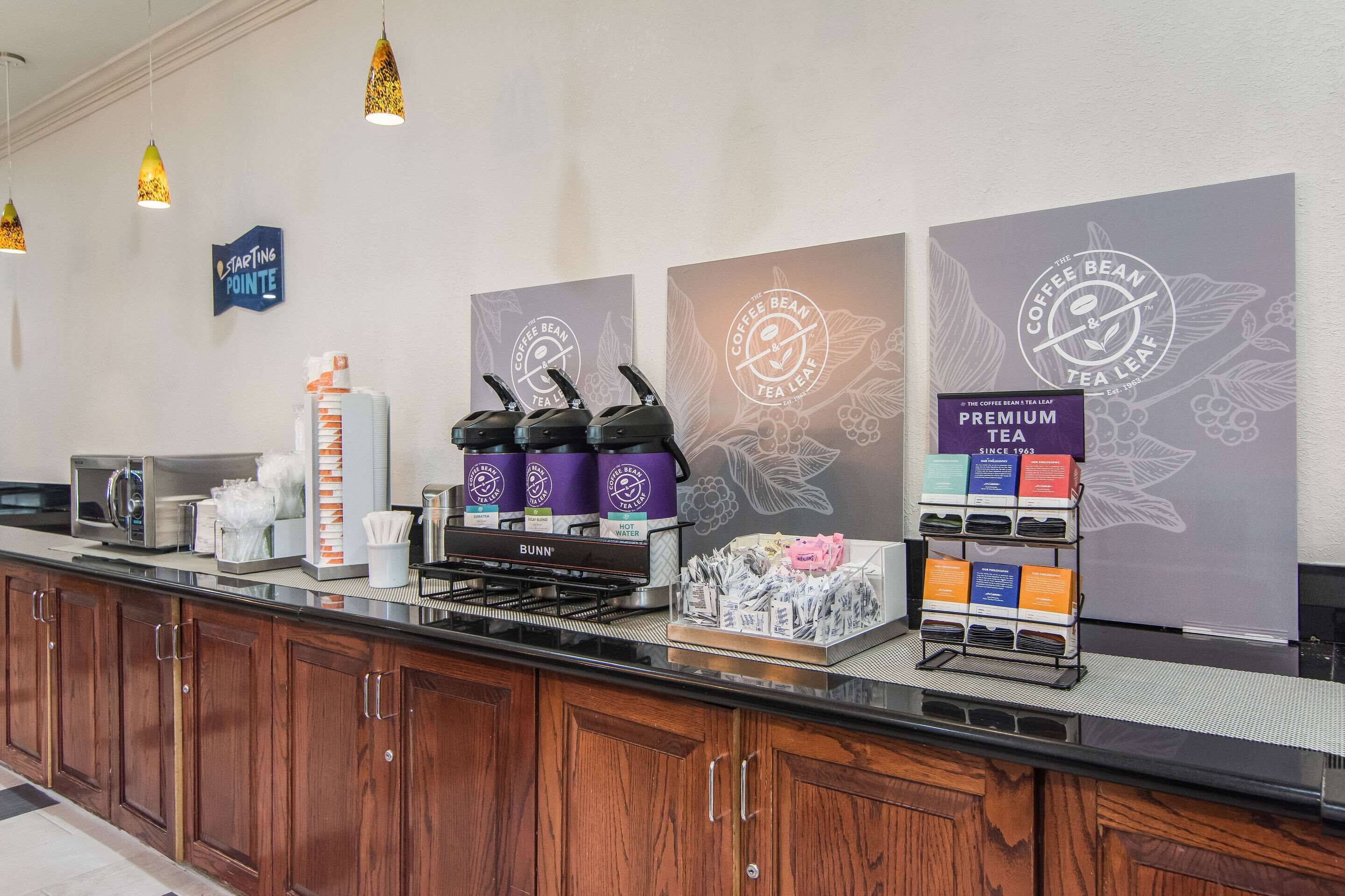 Una estación de café con dispensadores de la marca, una máquina de café y una presentación de tés.