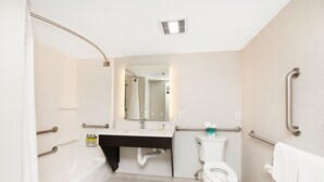 A modern bathroom with a bathtub, toilet, and sink. It includes grab bars and a shower curtain. - Holiday Inn Express & Suites Delafield by IHG (Delafield)