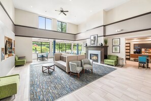 A spacious living area with a fireplace, seating, and large windows.