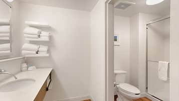 A modern bathroom with a white sink, toilet, and shower.