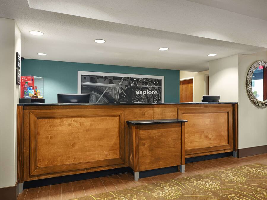 A reception desk with a teal wall, wooden panels, and a framed black and white photo.