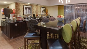 Un comedor con una isla central, sillas y una disposición tipo bufé.