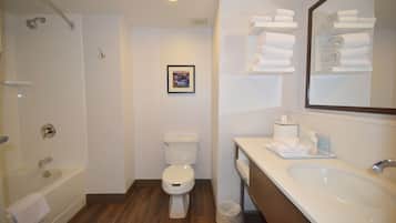 Een moderne badkamer met een bad, toilet en wastafel.