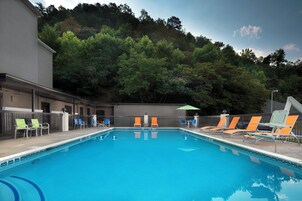 Una piscina al aire libre, sillones reclinables de piscina
