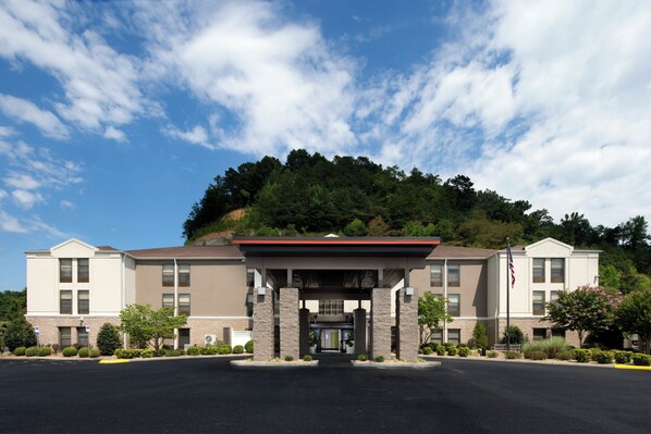 A two-story hotel with a covered entrance and a parking lot in front.