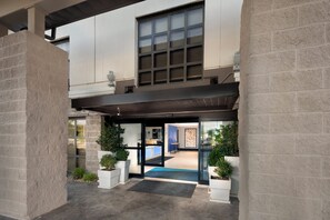 A hotel entrance with a covered walkway, potted plants, and a reception area. - Holiday Inn Express Middlesboro by IHG (Middlesboro)