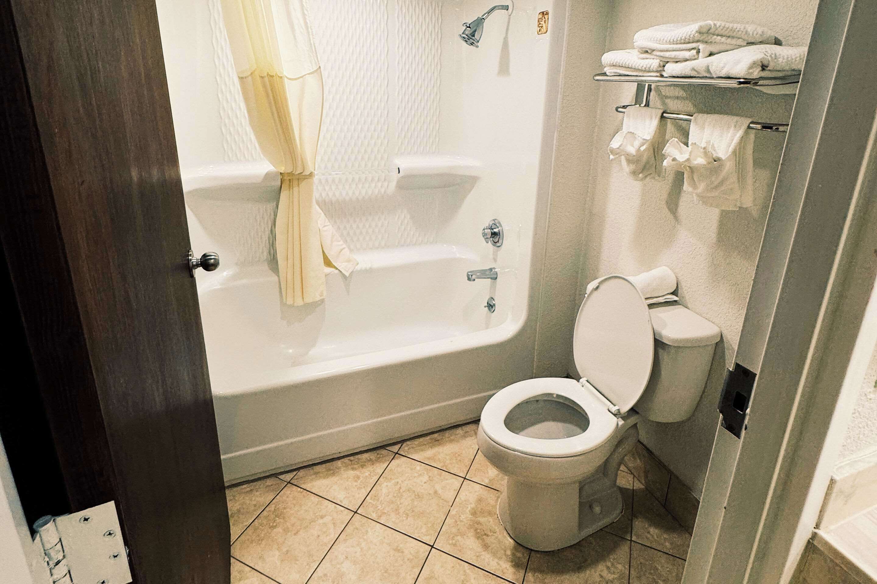 Ein Badezimmer mit Badewanne, Toilette und Handtuchhalter.