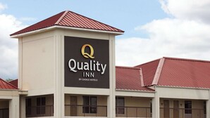 A multi-story hotel with a prominent sign for Quality Inn by Choice Hotels. - Quality Inn near Chattanooga South (Ringgold)