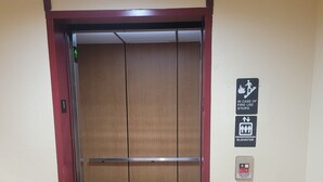 An elevator with a wooden finish, a fire use stairs sign, and an elevator sign on the wall. - Super 8 by Wyndham Show Low (Show Low)