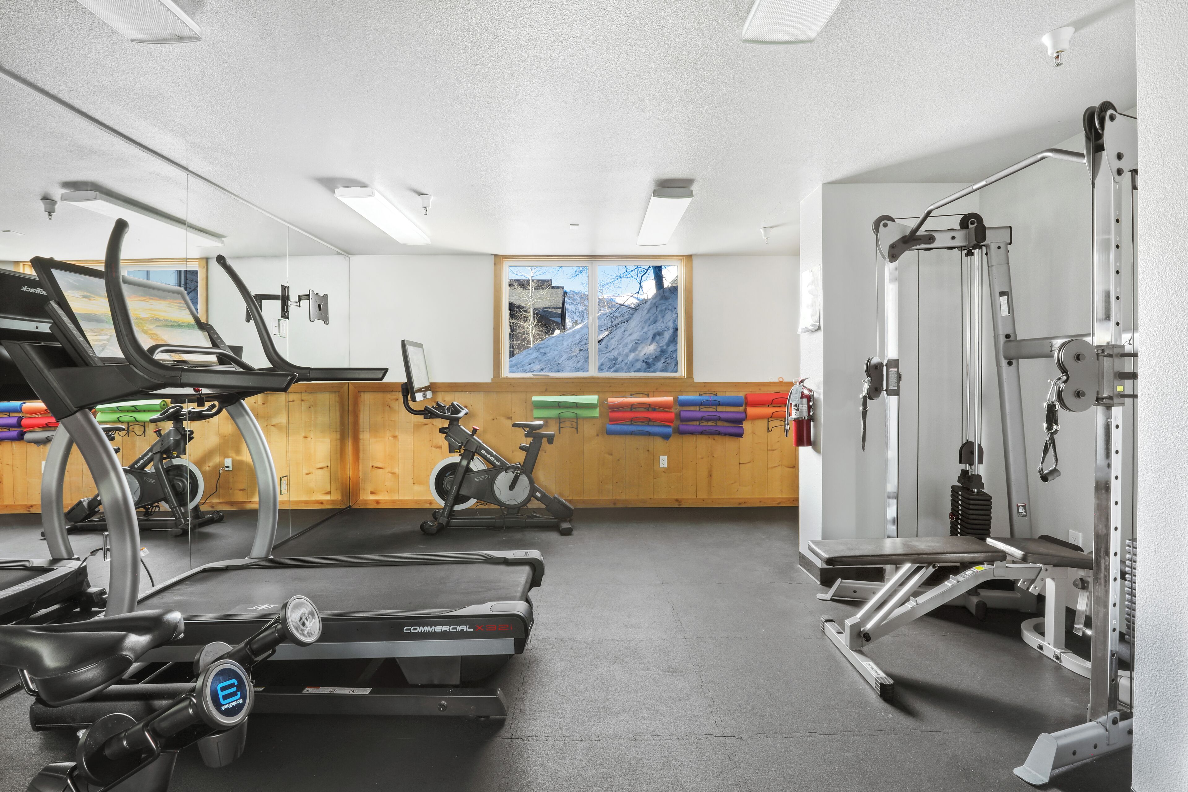 Ein Fitnessstudio mit Laufbändern, Ergometer und Gewichten.