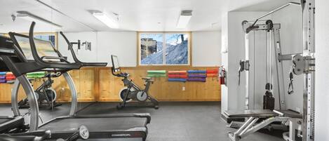 Ein Fitnessstudio mit Laufbändern, Ergometer und Gewichten.