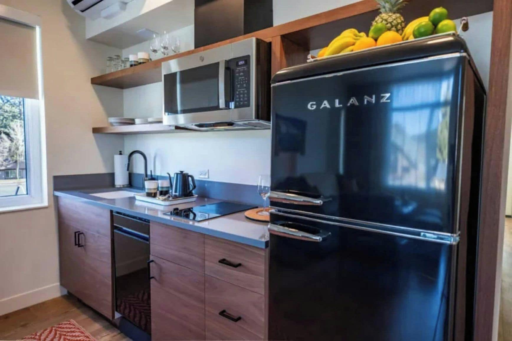 A compact kitchen with a black Galanz refrigerator, a microwave, and a sink.