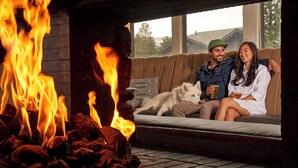 A cozy living room with a fireplace, a sofa, and a dog. - Outbound Mammoth  (Mammoth Lakes)