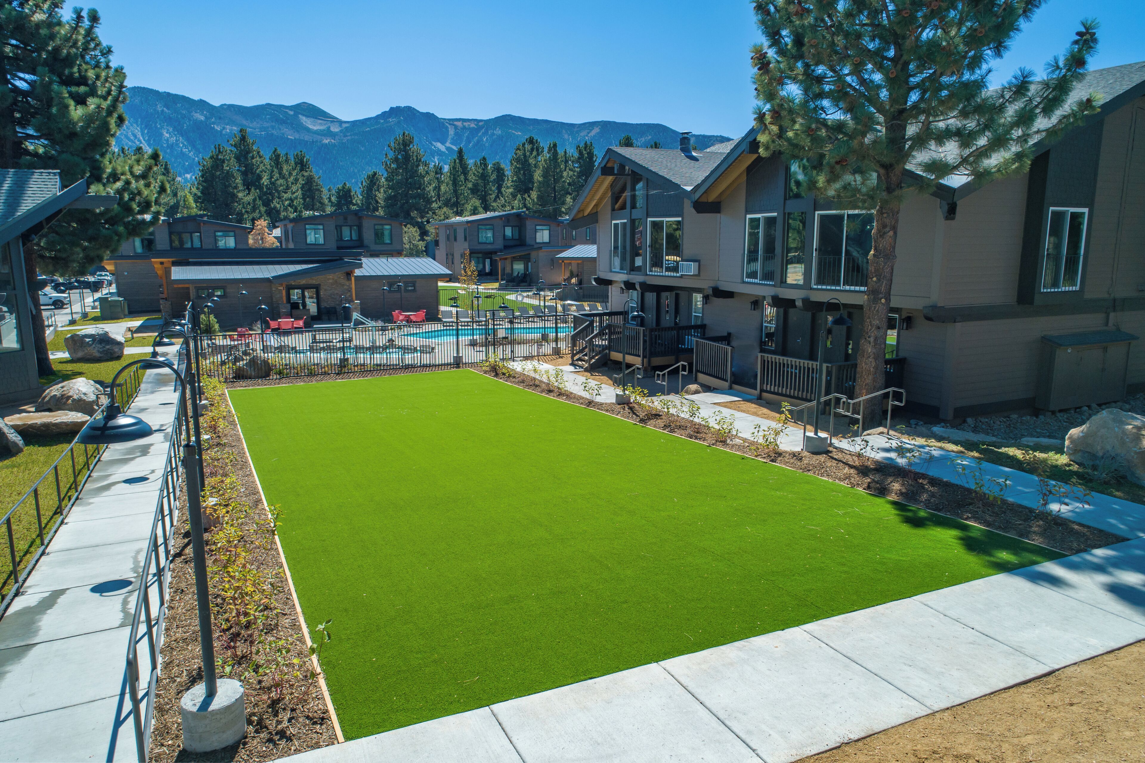 A residential area with modern houses, a swimming pool, and a well-maintained lawn.