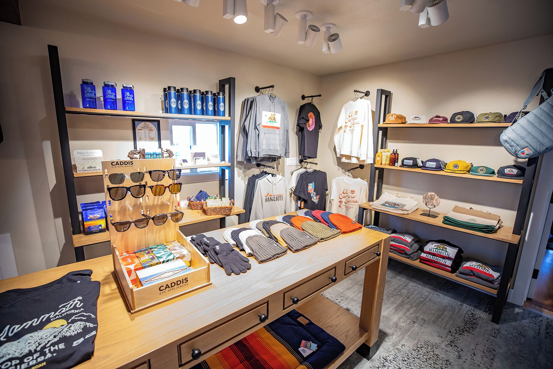 A retail store with shelves of sunglasses, hats, and clothing.
