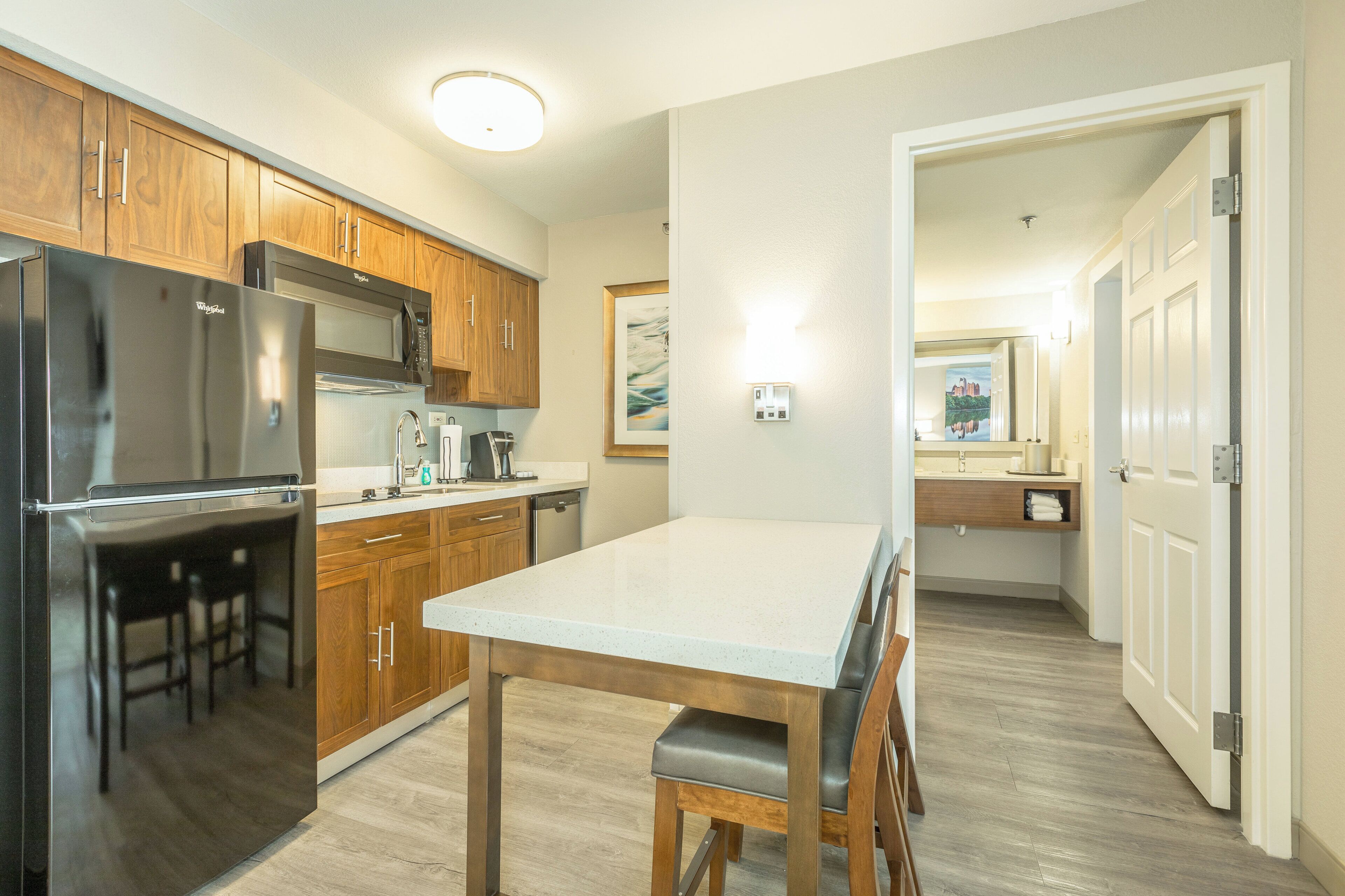 Una cocina moderna con electrodomésticos de acero inoxidable, armarios de madera y una zona de comedor con mesa y sillas.