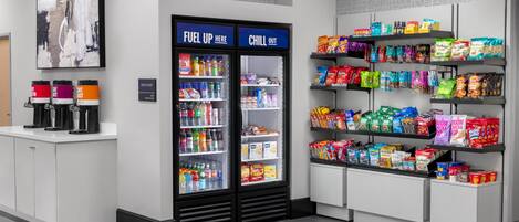 A snack bar with a beverage cooler, snack shelves, and a coffee station.