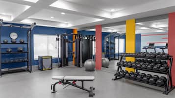 Een sportschool met gewichthefapparatuur, dumbbells en trainingsballen.