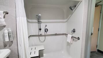 Ducha a nivel con barra de apoyo, cabezal de ducha manual y grifo de mano.