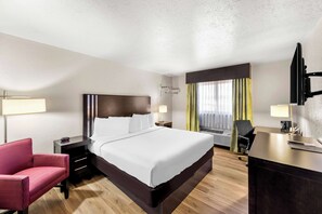 Relax in a spacious room with a large bed, bedside table, and flat-screen TV.