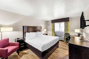Relax in a spacious room with a large bed, bedside table, and flat-screen TV.