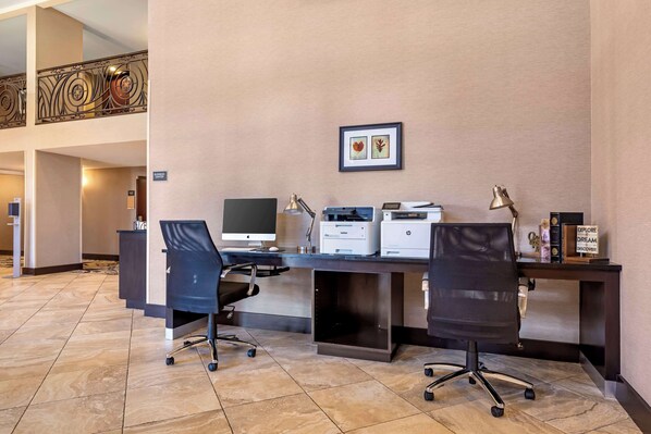 A hotel office area with a desk, two chairs, a computer, printers, and a framed picture on the wall. - Best Western New Albany (New Albany)