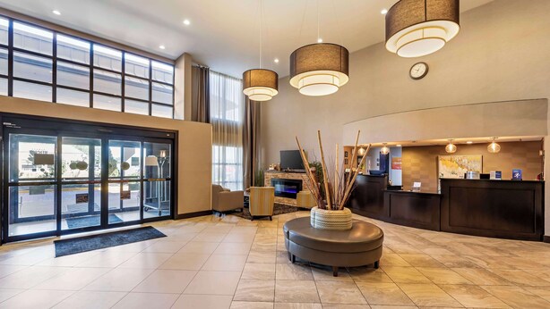 Un moderno vestíbulo de hotel con mostrador de recepción, zona de estar y amplios ventanales.
