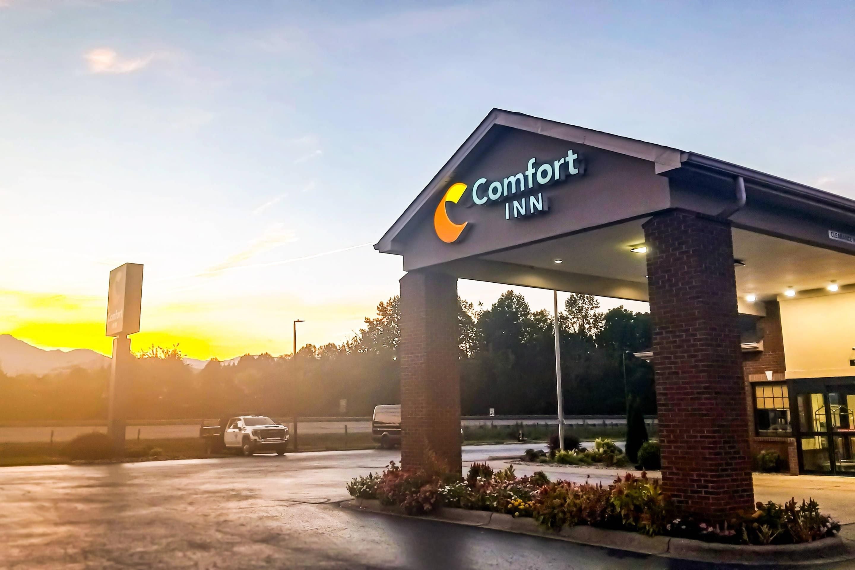 A Comfort Inn hotel entrance with a covered parking area and a clear sky.