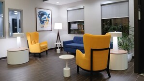 A modern lobby with two yellow armchairs, a blue sofa, a round table, and a floor lamp. - Comfort Inn Marion near Downtown & Blue Ridge PKWY (Marion)